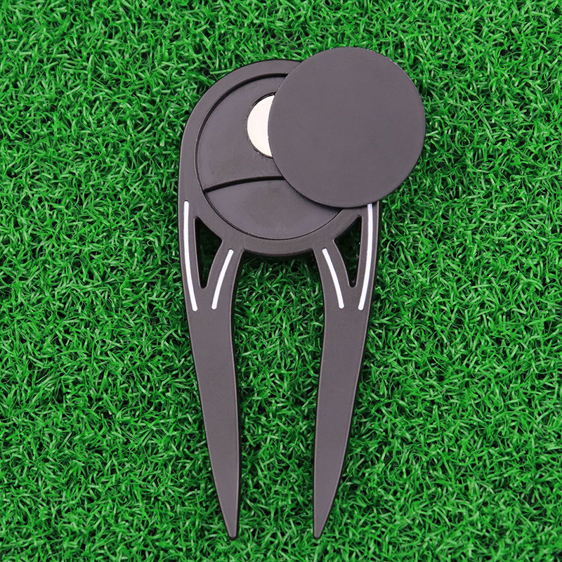 Golf divot tool on a green grass background