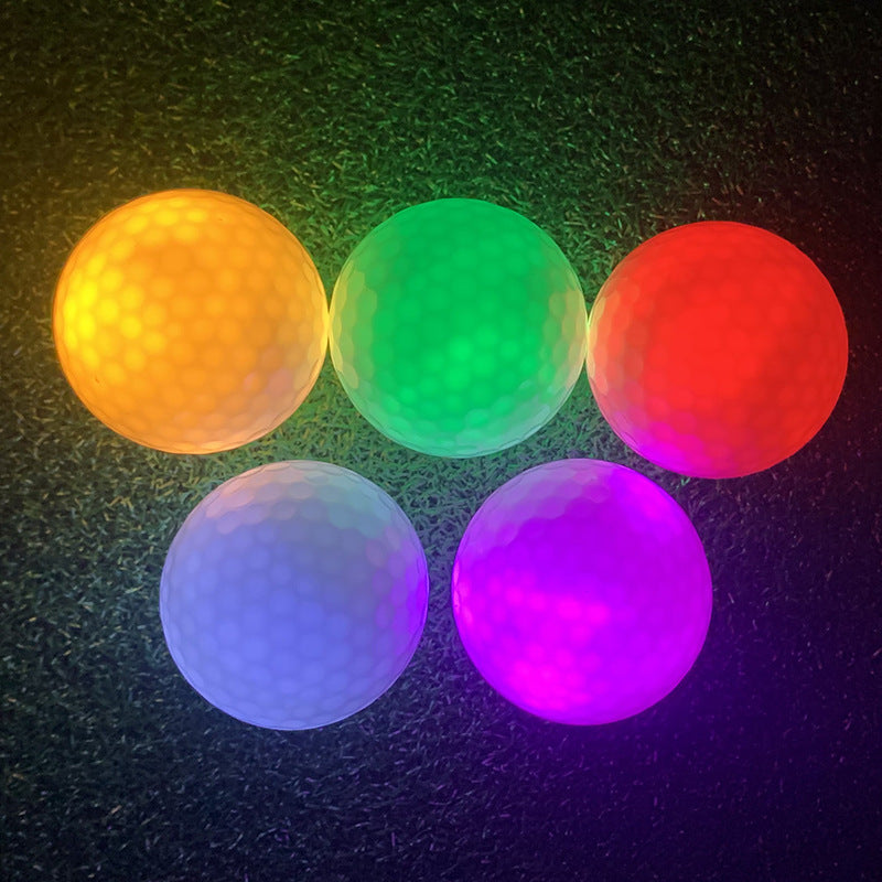 Five glowing golf balls in orange, green, red, white, and purple
