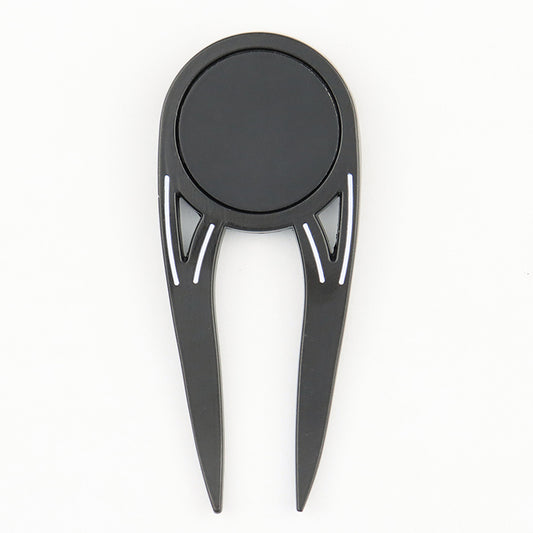 Black golf divot tool with a central ball marker on a white background