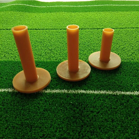 Three orange Golf Rubber Tee on a green artificial grass surface